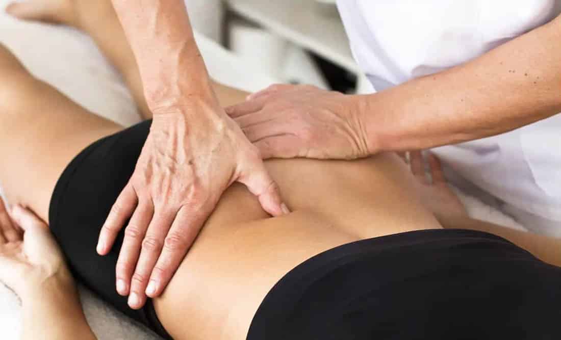 fisio dando masaje en la espalda a una paciente