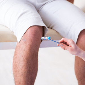 medico golpeando la rodilla del paciente