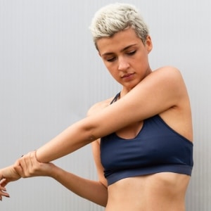 mujer estirando el brazo