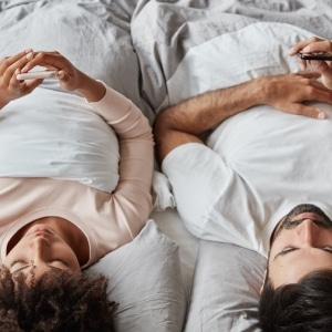 pareja en la cama mirando el movil